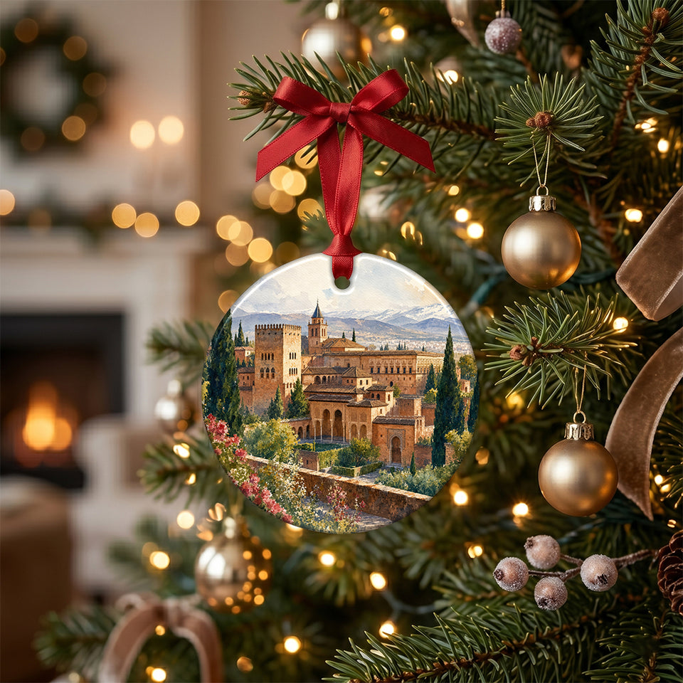 Alhambra holiday ornament hanging on an illuminated Christmas tree branch among warm lights.