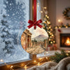 Ceramic travel ornament suspended in front of a bright frosty window with soft daylight.