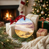 National park souvenir ornament placed beside wrapped holiday gifts near a warm hearth.