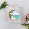 Opened white gift box presenting the ceramic Cancún travel ornament ready for holiday gifting.