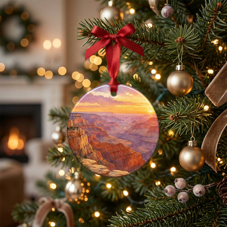 Round ceramic national park decoration placed on a rustic holiday table with pinecones and a candle.