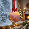 Watercolor Arizona landscape ornament catching soft daylight beside a frosty winter window.