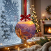 Round canyon sunrise ornament suspended before a frosty winter window catching gentle daylight.