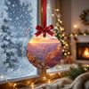Sunrise canyon art ornament catching natural winter daylight in front of a frosty window.