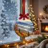Winter landscape ornament suspended in front of a frosty window overlooking the daylight.