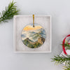 Travel souvenir ornament resting inside an opened white gift box ready for holiday presentation.