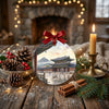 Round travel keepsake arranged on a holiday table setting accompanied by seasonal pinecones and candlelight.
