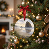 Round coastal ornament hanging neatly on an evergreen holiday tree branch with glowing lights.