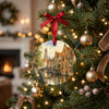 Holiday decoration featuring Bruges canal artwork hanging gracefully from an illuminated Christmas tree branch.