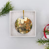 Carefully packaged round ceramic Bruges holiday keepsake nestled inside an open white gift box.