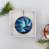 Northern lights souvenir ornament displayed inside an opened white gift box ready for holiday giving.