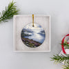 Ceramic Scottish Highlands ornament packaged inside an open white gift box ready for gifting.