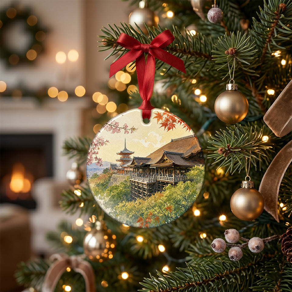 Ceramic holiday keepsake ornament featuring Kyoto temple hanging from a brightly lit Christmas tree branch.