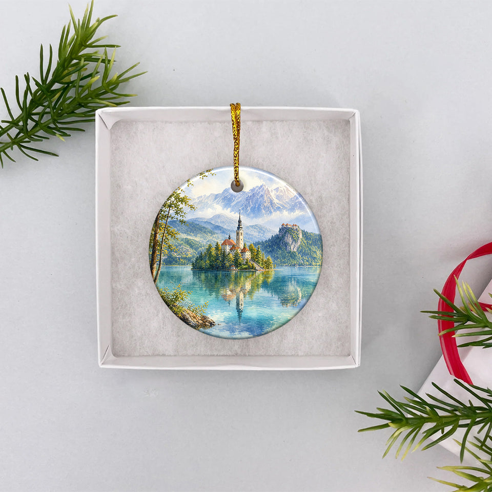 Double-sided ceramic Lake Bled ornament nestled securely inside an open white gift box.