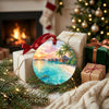 Ceramic holiday ornament resting beside wrapped seasonal gifts and a glowing living room fireplace.