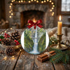 Festive holiday display showing the waterfall ornament on a table alongside pinecones and a candle.