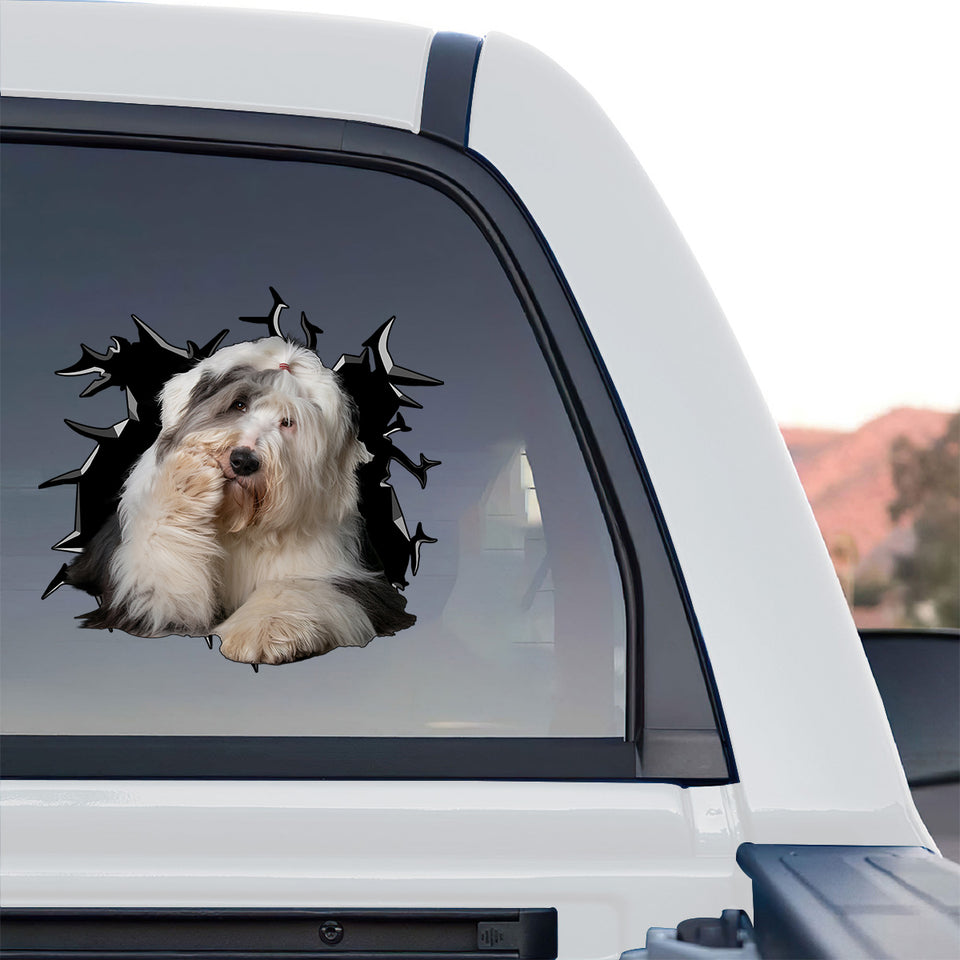Glossy Old English Sheepdog decal adhered to the rear window of a truck outdoors.