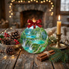 Decorative Croatia park ornament styled on a rustic table next to a pinecone and candle.