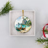 The round ceramic keepsake resting inside an opened white gift box ready for holiday gifting.