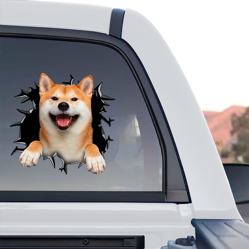 Adorable Shiba Inu dog sticker decorating the rear window of a truck parked outdoors in the sunlight.