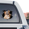 Funny broken glass puppy sticker decorating the rear window of a truck outdoors.