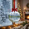 Scenic Grand Teton ornament catching winter morning daylight while hanging in front of a frosted window