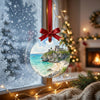 Round holiday ornament catching natural sunlight as it hangs in front of a frosty winter window.
